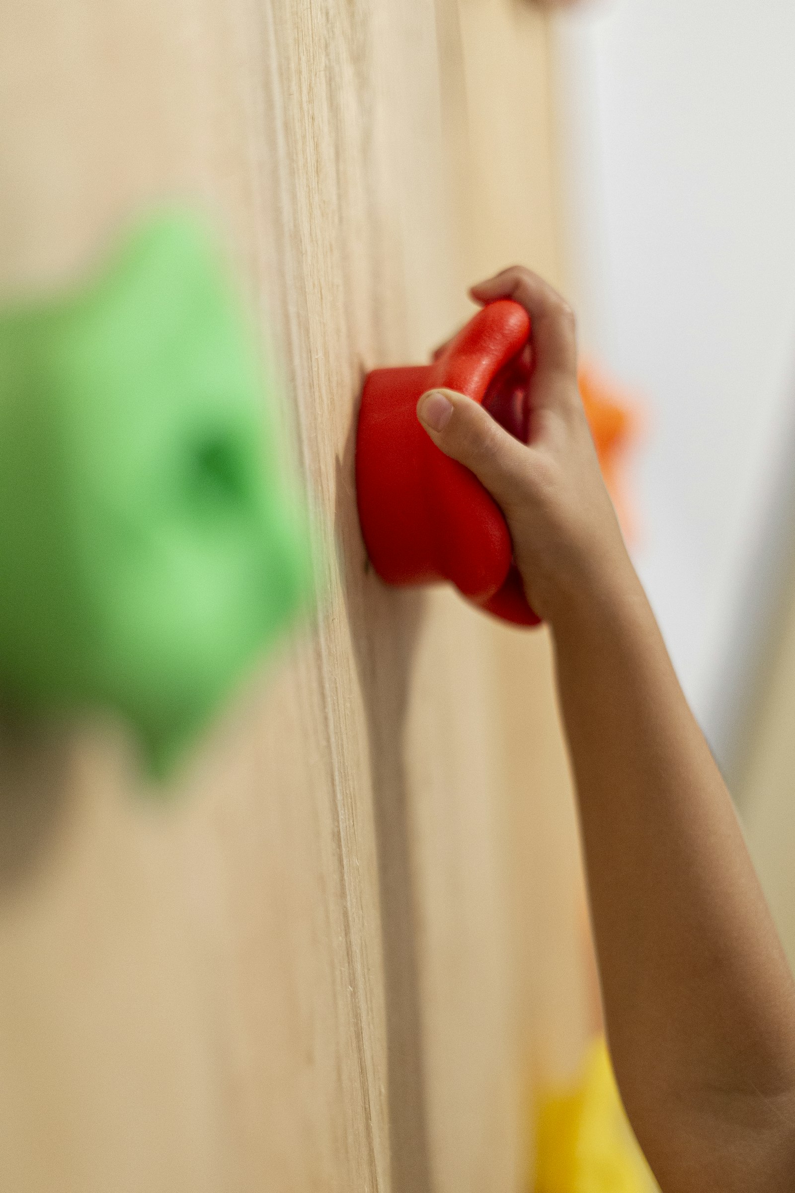 Griff an einer Kletterwand mit Kinderhand