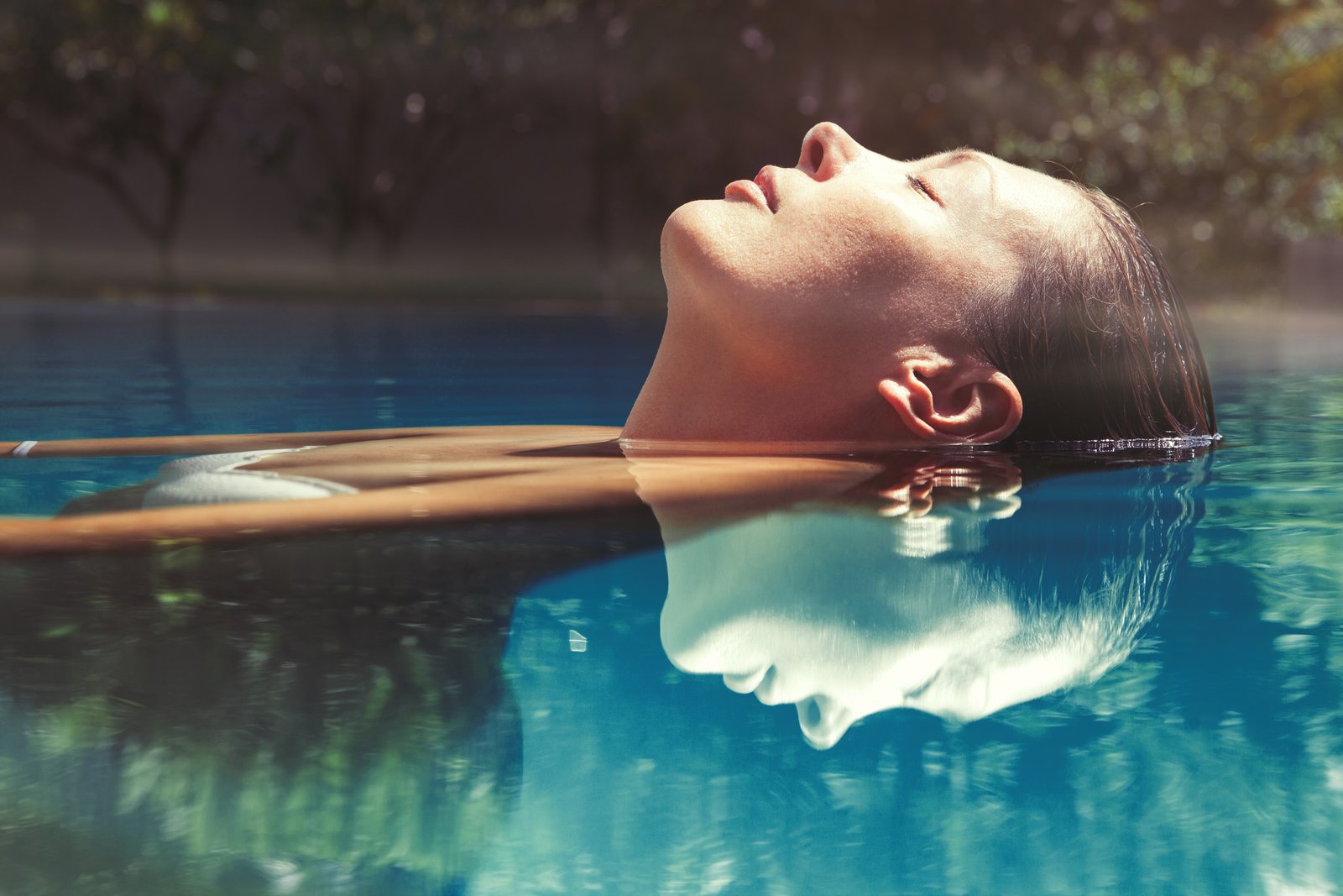 Frau entspannt im Wasser eines Pools