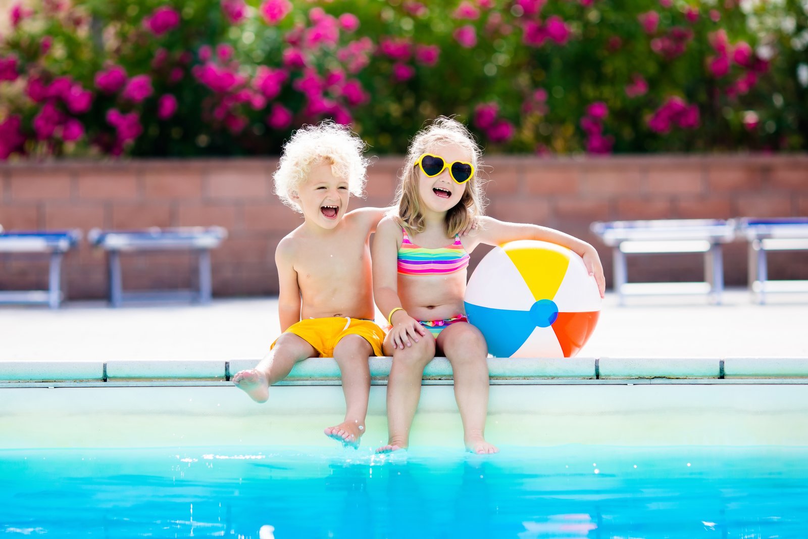Zwei Kinder am Rand eines Schwimmbeckens