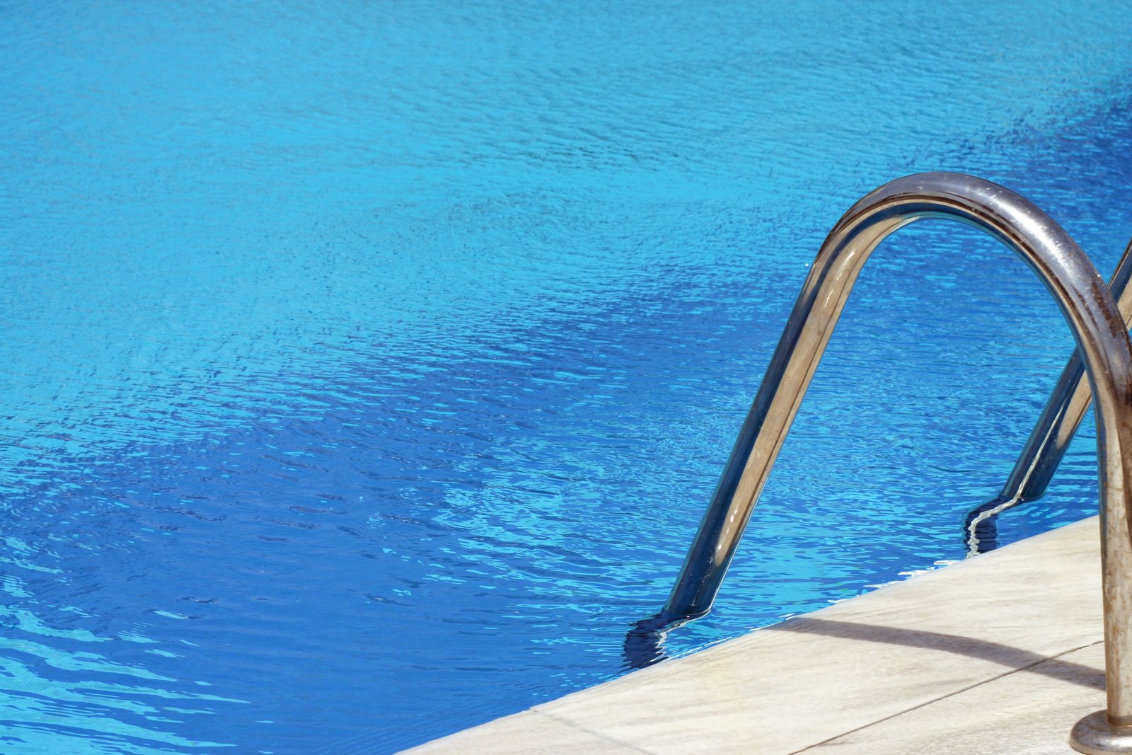 Poolleiter an einem blauen Schwimmbecken